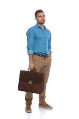 young casual man looking away, holding his briefcase