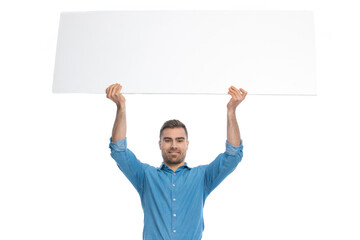 handsome casual man holding a wide billboard overhead