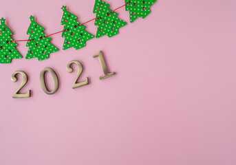 Christmas 2021. Coronavirus new year minimal concept. Flat lay with metal numbers and pattern christmas trees on pink background. Top view, copy space