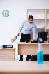 Young male employee cleaning office during pandemic