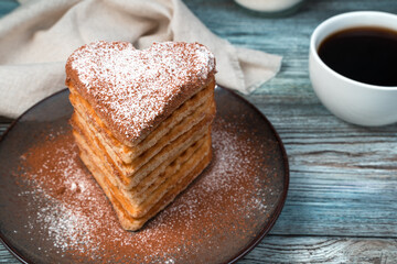 French dessert, waffles with cocoa and vanilla on a wooden gray background. Side view. Concept of festive culinary backgrounds.