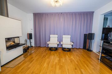 Beautiful interior view of modern decorated room in private home. White fire place , hi-fi speakers...