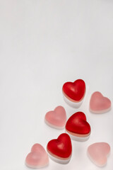 Red gelatin hearts on a white background and with space for text. Valentine's day concept.