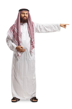 Full Length Portrait Of A Saudi Arab Man Wearing A Traditional Thobe And Pointing To The Side