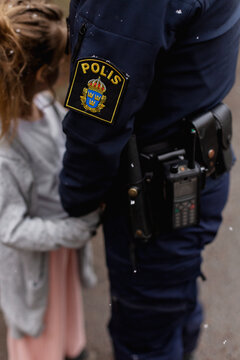 Police woman holding girls hand, Sweden