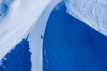 Drone image of mountains in winter. Image with snow, texture and shadows. 