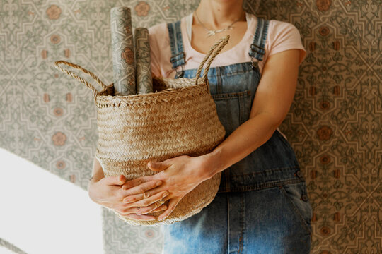 Woman holding basket with wallpaper rolls, Sweden