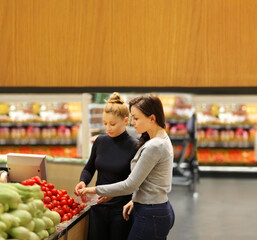 two women buying fruits at the market