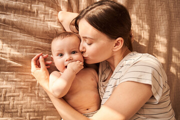 Woman kissing to the chic her newborn