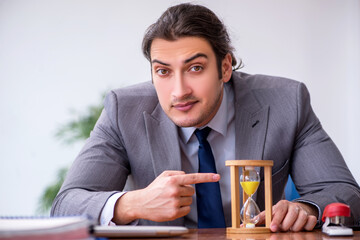 Young male employee in time management concept