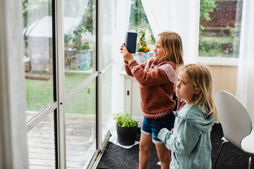 Girls looking through window, Sweden