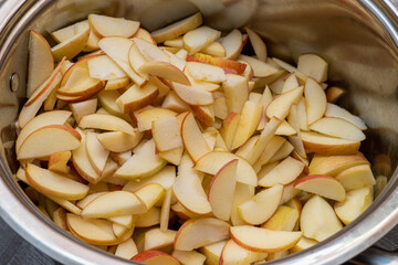 pan, bowl full of sliced apples for jam, marmalade cooking
