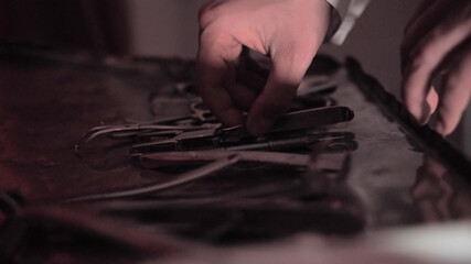 Medical instruments for torture in a metal tray in a bloodied room