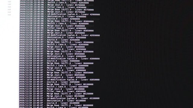 White computer software code moving on a black monitor. Computer hacking in process, dynamic text running and flowing on pc screen.