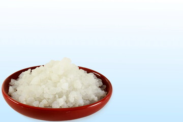 camphor or cinnamomum camphora crystal in bowl on blue white background with copy space