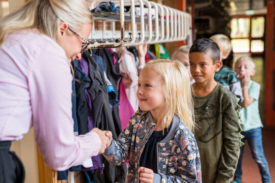 Teacher greeting children, Sweden