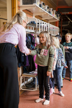 Teacher greeting children, Sweden