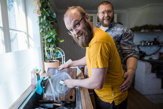 Smiling man washing dishes, Sweden