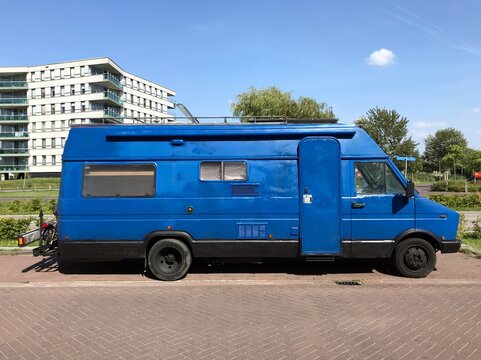 Almere, the Netherlands - August 22, 2019: Hand painted Blue 1980's Fiat camper van parked by the side of the road. Nobody in the vehicle.