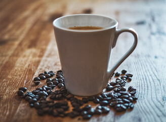 Kaffeetasse und Kaffeebohnen auf dem Holztisch
