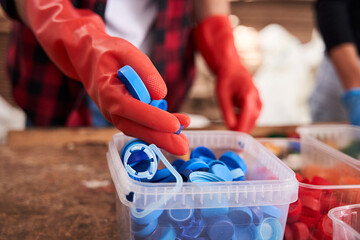 Man sorting plastic caps for the colors