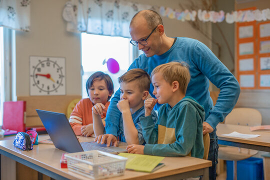 Teacher helping boys in classroom, Sweden