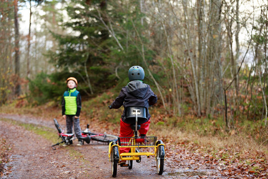 Boys cycling through forest, Sweden