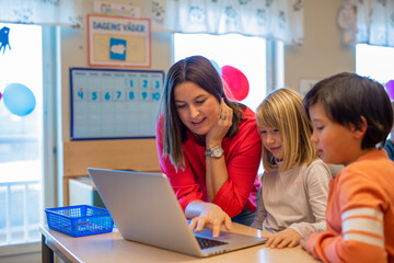 Teacher helping children in classroom, Sweden