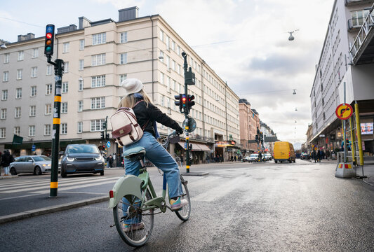 Woman cycling in city, Sweden
