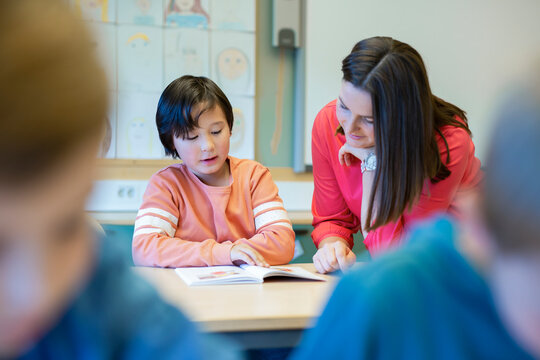 Teacher helping boy in classroom, Sweden - Powered by Adobe