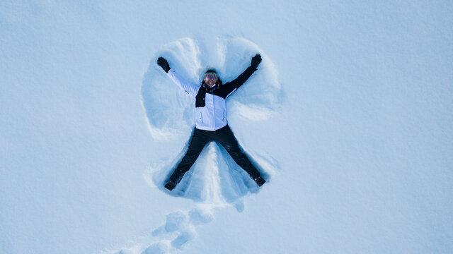 Woman making snow angel, Sweden
