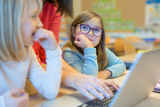 Teacher helping girls in classroom, Sweden
