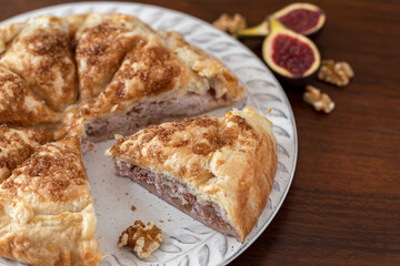 Close up of a ricotta cheese, figs and walnut puff pastry pie.