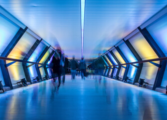 Long Exposure of commuters walking through crossrail canary wharf station in London, UK