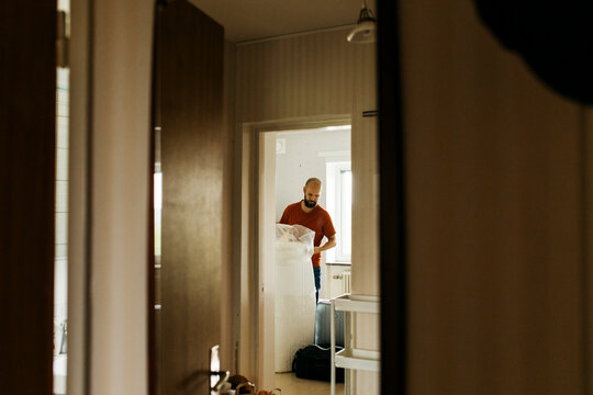 Man covering mattress in foil, Sweden
