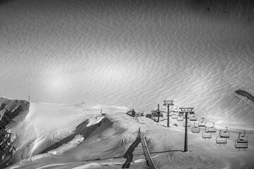 Empty ski lift in winter ski resort - Holidays. Winter landscape of mountain covered of snow in black and white. Glaciers 3000, Diablerets, Switzerland.