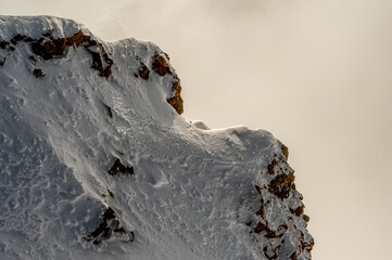 Isolated rock covered by snow in winter. Glaciers 3000, Diablerets in Switzerland.