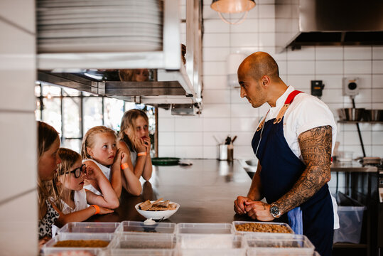 Girls watching chef working in restaurant kitchen, Sweden