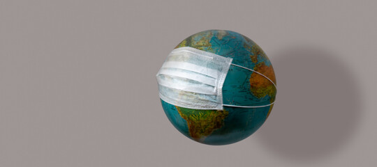 Corona virus global outbreak pandemic epidemic medical. Medical respiratory mask that protects the population of the earth globe on a grey background.