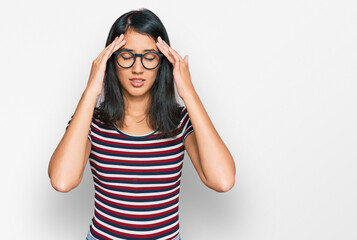 Beautiful asian young woman wearing casual clothes and glasses with hand on head for pain in head because stress. suffering migraine.