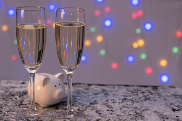 two full glasses of champagne and a piggy bank in the shape of a pig are on the table