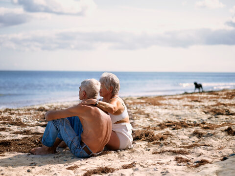Older couple sitting at beach, Denmark