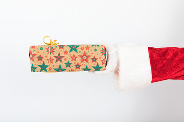 Arm of Santa Claus holding a gift from the right side on a white background. Chistmas concept