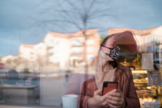 Woman with face mask using phone, Sweden