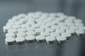 White pills on glass table