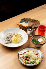Substantial lunch with stroganoff, caesar salad and soup on a wooden table, studio shot