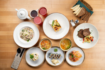 Continental lunch on light wooden table, variety of meals on a table top view