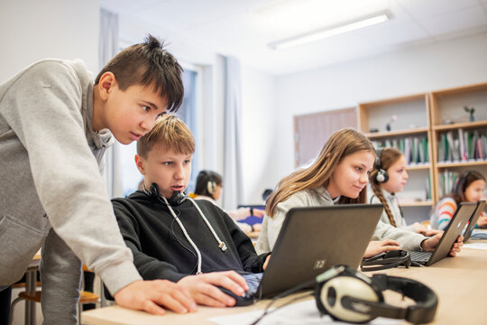 Boys in classroom using laptop, Sweden