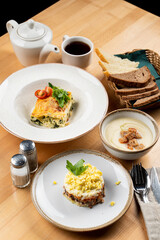 Beef lasagna, mushroom cream soup and layered fish salad as a lunch in a cafe, side view