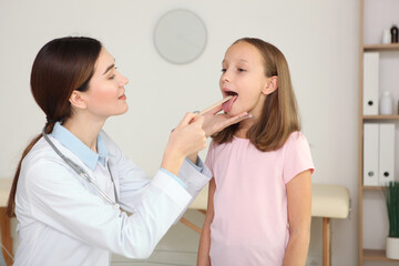 Young girl doctor pediatrician makes a checkup to a little girl